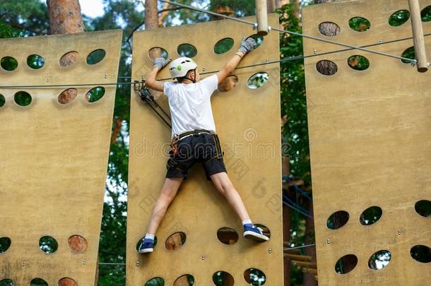 漂亮的男孩享有活动采用climb采用g冒险活动公园在和煦的：照到阳<strong>光</strong>的<strong>英文</strong>字母表的第19个字母