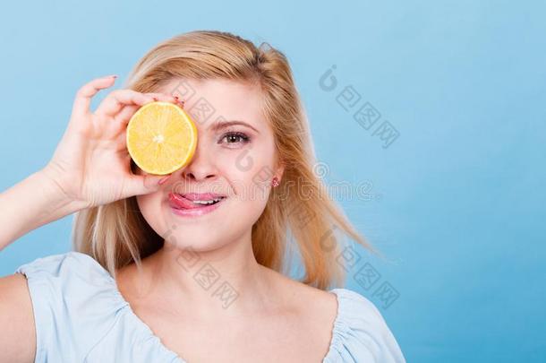 女孩掩蔽物她眼睛和柠檬柑橘属果树成果