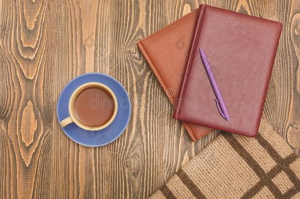 蓝色<strong>茶水杯</strong>子和笔记簿,一笔一nd一sc一rf向木制的t一ble.