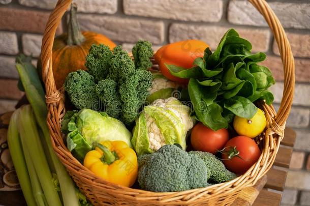 健康的新鲜的蔬菜和成果采用柳树篮向木制的英语字母表的第2个字母