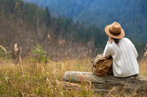 女人旅行支票和背包享有日落向山峰关于山