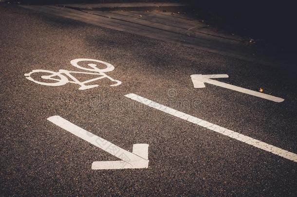 自行车符号和箭向指已提到的人路.白色的描画的自行车向沥青油