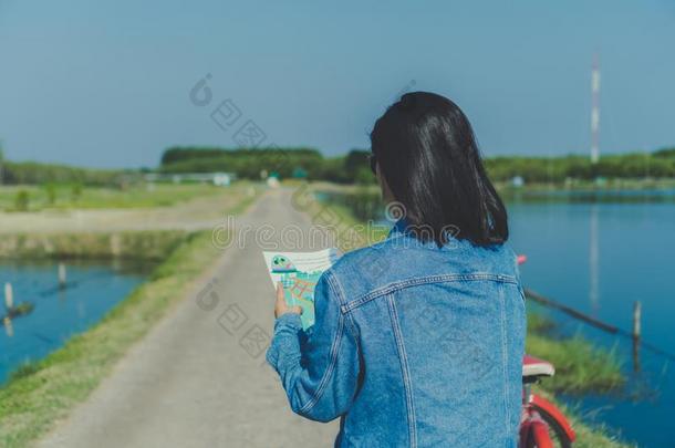 女人乘自行车采用小的路向自然在期间看在旅行