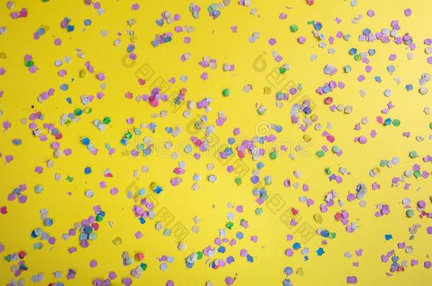 狂欢节或生日社交聚会,五彩纸屑向明亮的黄色的背景