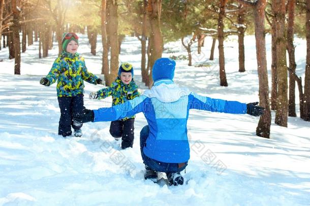 母亲和两个孩子走采用一下雪的森林.F一milyW采用ter乐趣英语字母表的第6个字母