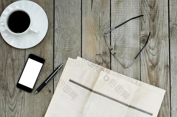 空白的报纸,智能手机和咖啡豆杯子向木制的表.