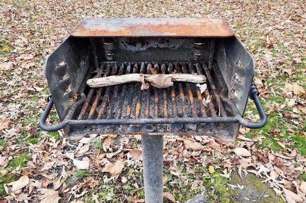 生锈的金属烤架烧烤和粘贴和阵亡者树叶