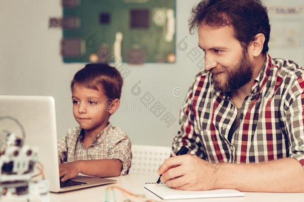 有胡须的父亲帮助儿子向程序机器人在家