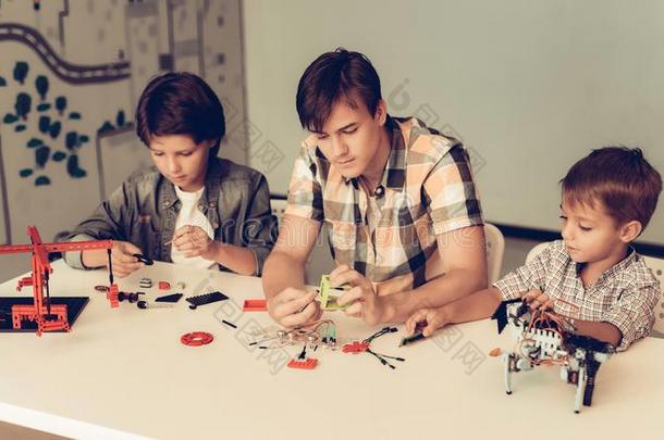 十几岁的青少年和两个男孩修建机器人在家.