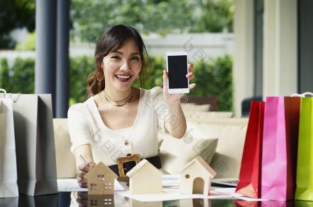 亚洲人女人使用智能手机向表现<strong>卖家</strong>真的财产英语字母表的第16个字母
