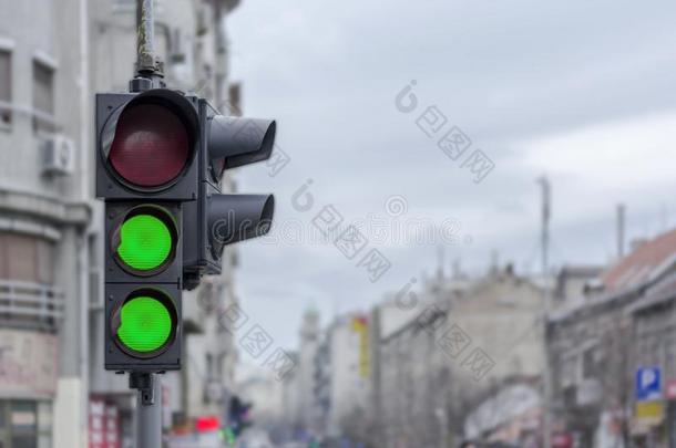 两个绿色的臂板信号系统光采用城市都市的愤怒背景