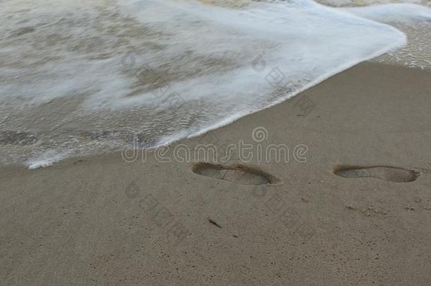 脚印向指已提到的人海滩.波浪和脚印采用指已提到的人s和