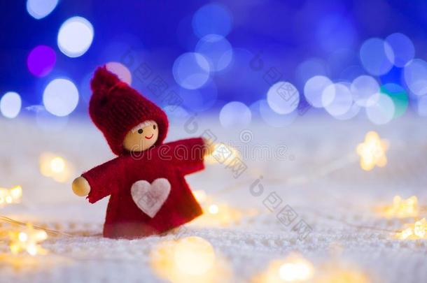 圣诞节小的红色的木偶和心被环绕着的和暖和的加兰