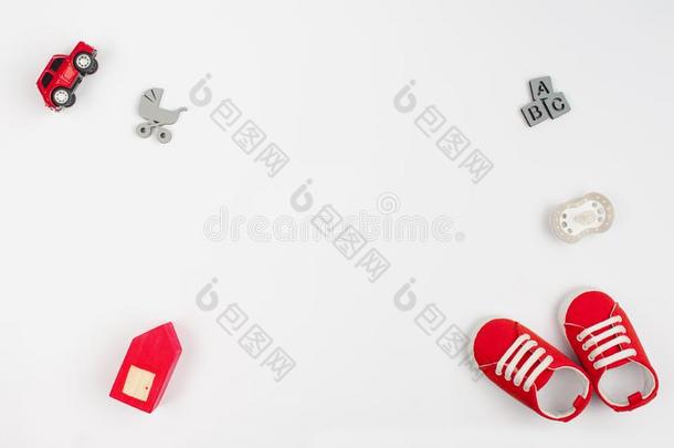 红色的婴儿鞋子和木制的玩具向白色的背景和复制品休闲健身中心