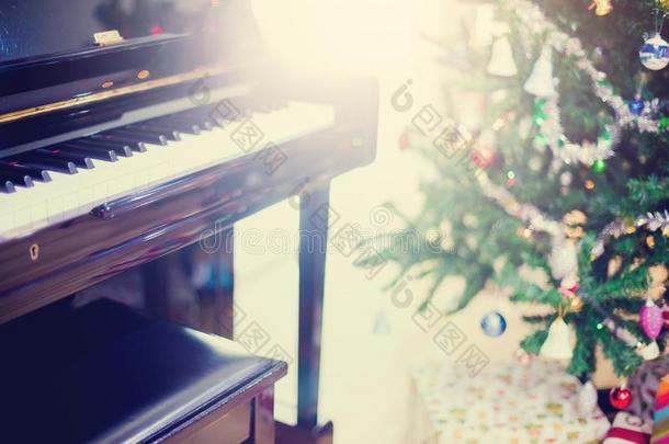 钢琴和发出光向圣诞节树为圣诞节假日后台