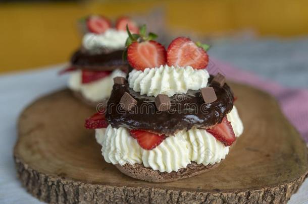 巧克力奶油水果蛋白饼和新鲜的草莓和鞭打乳霜