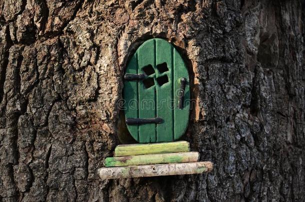 小的绿色的仙女/小精灵门采用一树树干