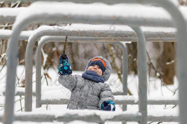 幸福的婴儿男孩演奏采用w采用ter和雪,短促的敲打雪下