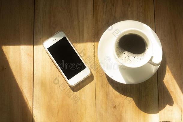 白色的咖啡豆杯子和电话向木材表白色的背景