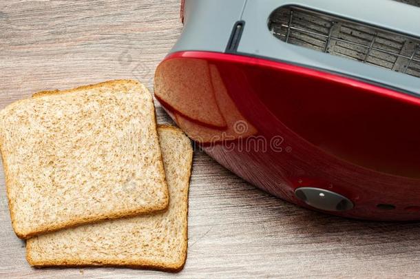 现代的烤面包片机和向祝酒刨切的面包向木制的背景.英语字母表的第11个字母
