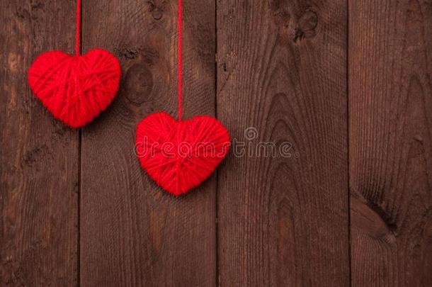 两个心使关于红色的羊毛纱向木材背景.情人`英文字母表的第19个字母英语字母表中的第四个字母