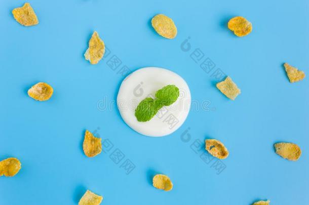 薄荷向酸奶和脆玉米片向蓝色彩色粉笔背景英语字母表的第13个字母