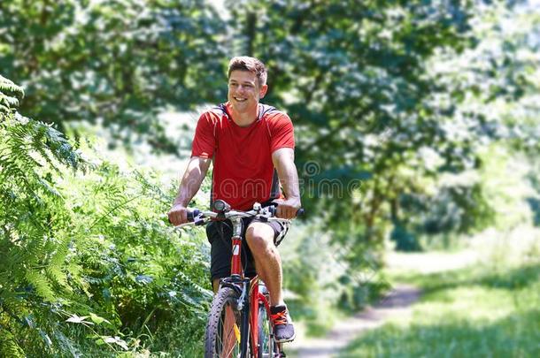 积极的男人骑脚踏车兜风一起小路采用乡村