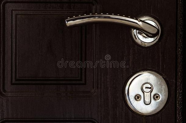 钢门和黑暗的棕色的质地.门球形把手和钥匙锁.