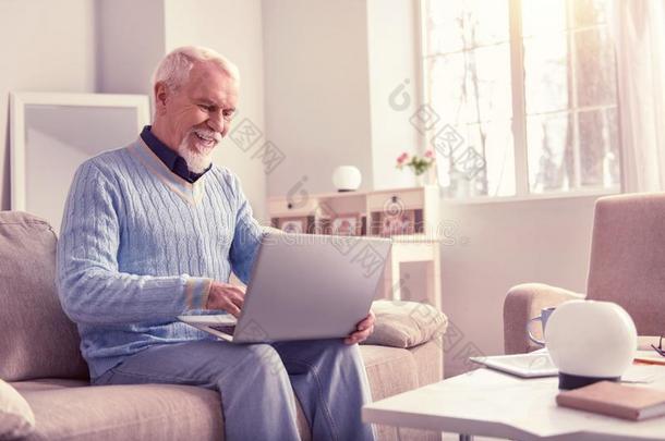 <strong>公开</strong>地微笑的上了年纪的男人工作的和便携式电脑