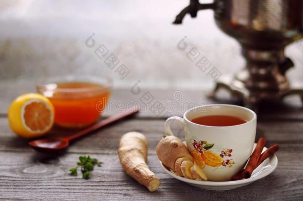 一杯子关于姜茶水,姜根,酿酒的俄国的一种茶壶,柠檬和int.引人注意