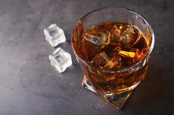 金色的威士忌酒采用玻璃和冰立方形的东西向表.