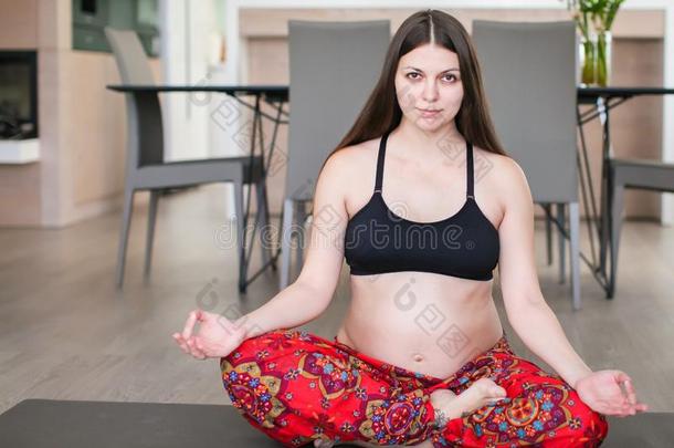 怀孕的女人瑜伽.怀孕的女孩锻炼在家.家中值
