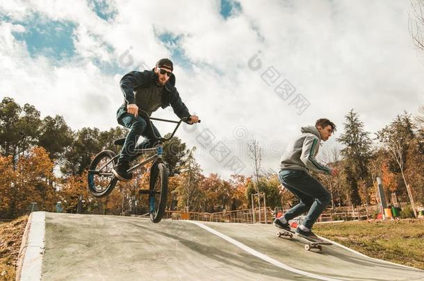 年幼的滑板运动员和bicyclemotorcross双轮摩托车越野赛自行车.年幼的人开业的都市的