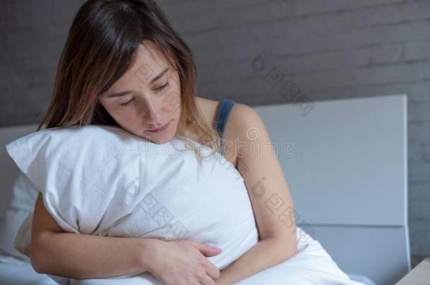 女人情绪低落的拥抱枕头采用床