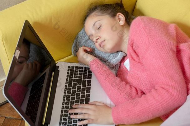 年幼的十几岁的青少年睡着的和便携式电脑