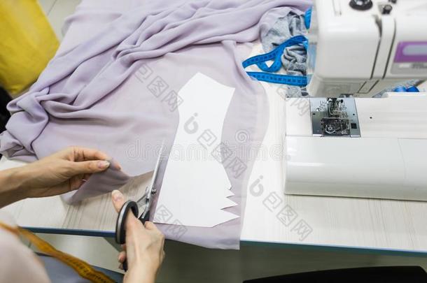 缝纫车间.女裁缝在使工作.标记和锋利的织物.
