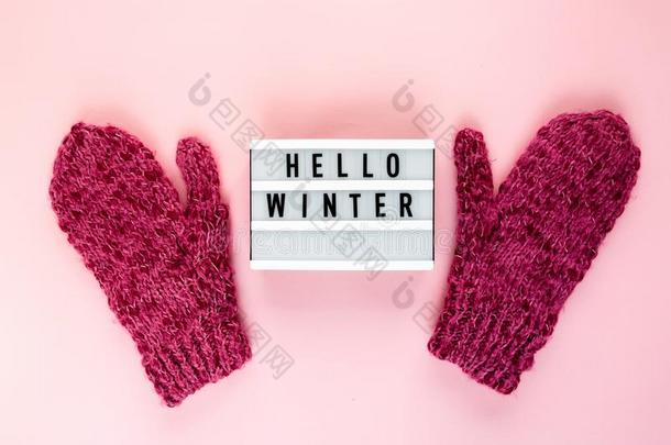 暖和的,舒适的冬连指手套,灯箱向彩色粉笔向粉红色的背景