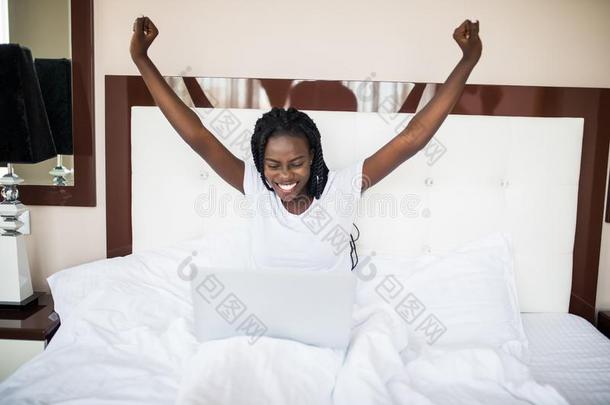 年幼的非洲式发型美国人女人获胜和庆祝尖声喊叫和便携式电脑我