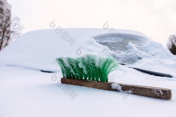 向指已提到的人被雪困住的汽车兜帽谎言一绿色的刷子.