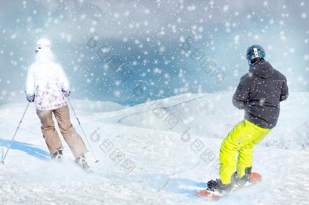 两个积极的朋友滑雪的人和雪山飞魂乘向山顶农业的