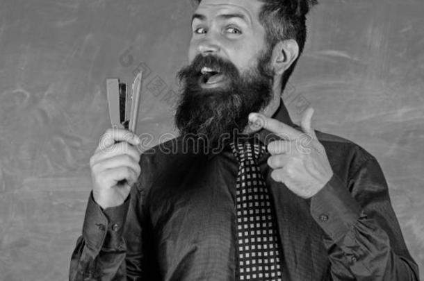 教师有胡须的男人和订书机黑板背景.准备