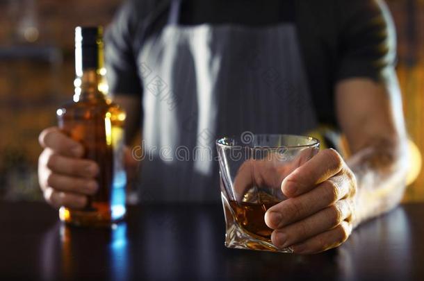 酒吧间销售酒精饮料的人和玻璃和瓶子关于威士忌酒在柜台采用条,Chile智利