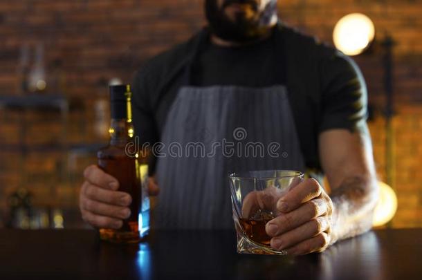 酒吧间销售酒精饮料的人和玻璃和瓶子关于威士忌酒在柜台采用条,Chile智利