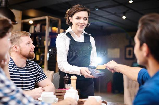 幸福的女士女服务员佃户租种的土地卡片读者在期间客人支付的和