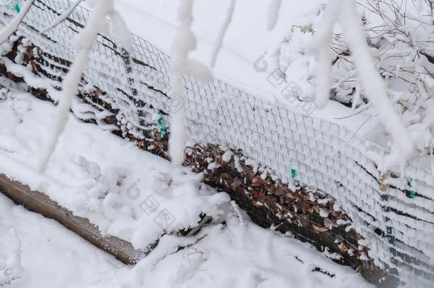 关在上面关于新鲜的雪涂层和压条法向花园金属丝栅栏