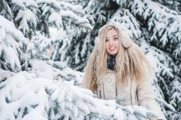 美丽的微笑的女人有一乐趣户外的向下雪的we一ther.