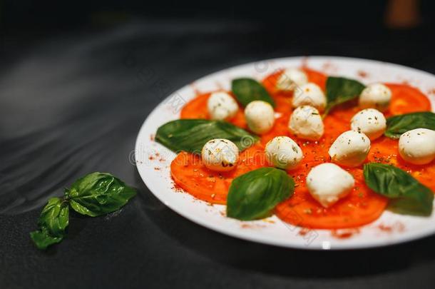 番茄和意大利干酪和迷迭香向<strong>白</strong>色的盘子隔离的向