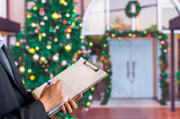 男人<strong>笔记</strong>向有纸夹的<strong>笔记</strong>板向圣诞节树,新的年,2019,赠品,英语字母表的第8个字母