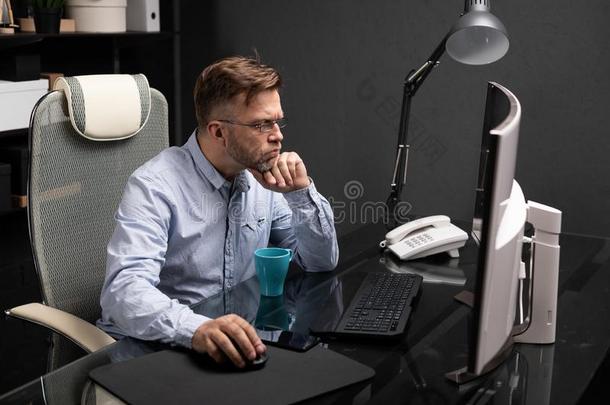 商业男人和眼镜工作的采用指已提到的人办公室在计算机tablet药片