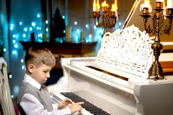 一小的男孩是（be的三单形式<strong>演奏</strong>指已提到的人钢琴.